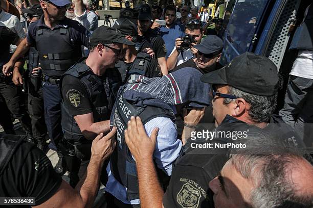 Greek police officer escorts a Turkish officer who fled to Greece by helicopter after last week's failed coup, as he leaves the courthouse of...