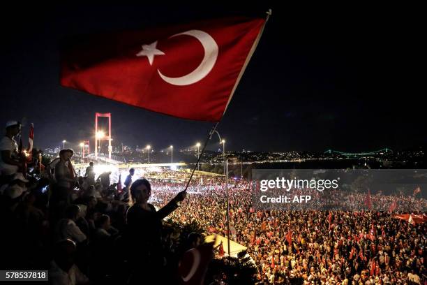 Pro Erdogan supporters wave a Turkish national flag during a rally at Bosphorus bridge in Istanbul on July 21, 2016. Thousands of Turkish government...