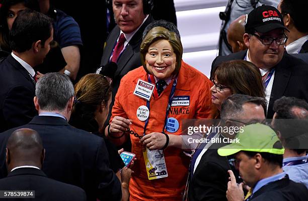 Delegate deseed as Hillary Clinton in a prison jumpsuit walks the floor of the Quicken Loans Arena at the 2016 Republican National Convention in...