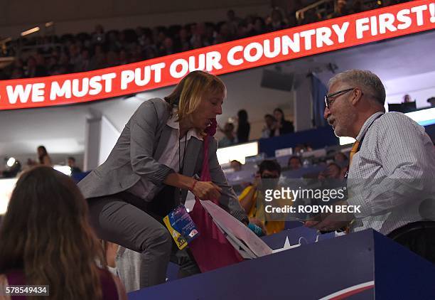 Code pink protester tries to pull up a banner as Republican presidential candidate Donald Trump arrives to speak on the last day of the Republican...