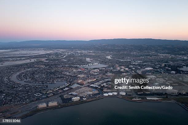 Aerial view of Silicon Valley at dusk, with a portion of the San Mateo/Hayward Bridge visible, as well as Foster City, including the California...