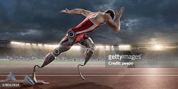 physically disabled athlete sprinting from blocks with artificial robotic legs - mens en machine stockfoto's en -beelden