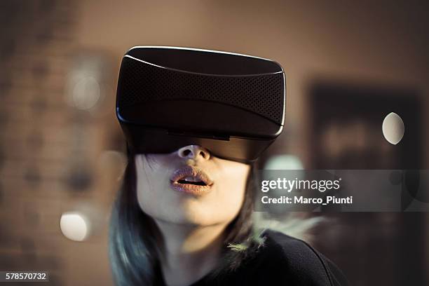 begeistert junge frau sieht in virtuellen reality-headset - 360 people stock-fotos und bilder