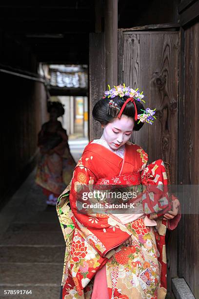 maiko girls standing in narrow path - geisha in training stock pictures, royalty-free photos & images