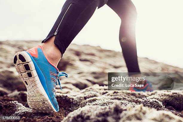 close up of trainers running through mossy terrain - zapatillas de deporte fotografías e imágenes de stock