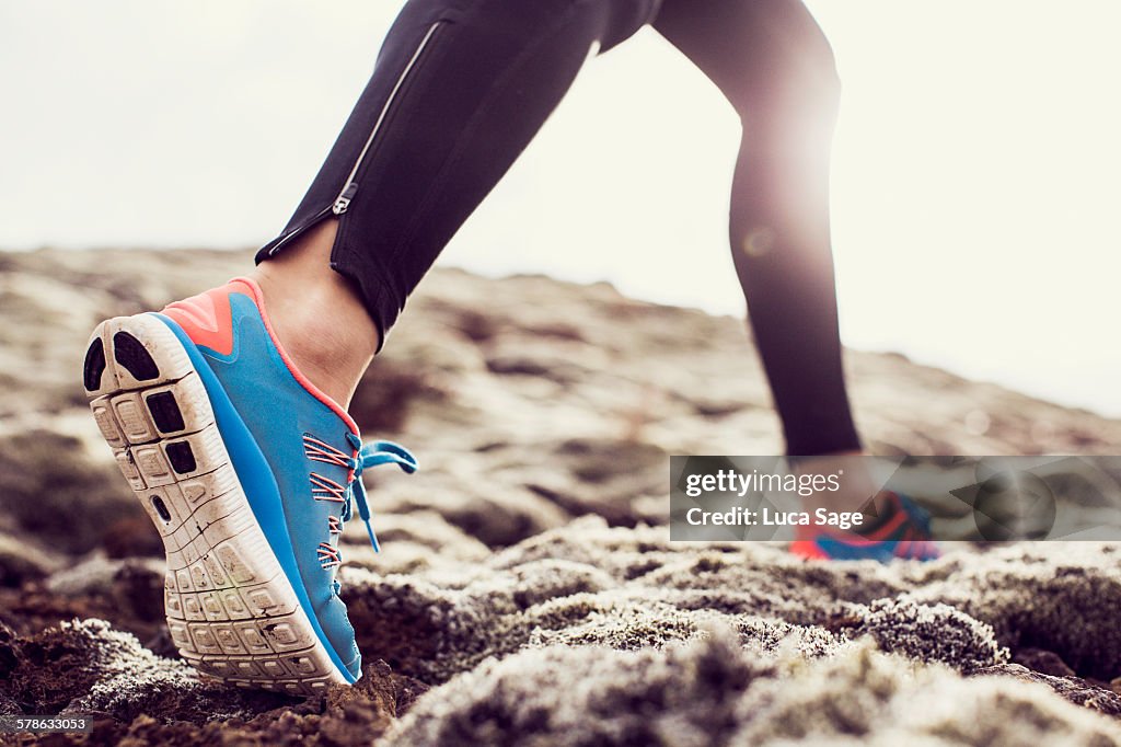 Close up of trainers running through mossy terrain