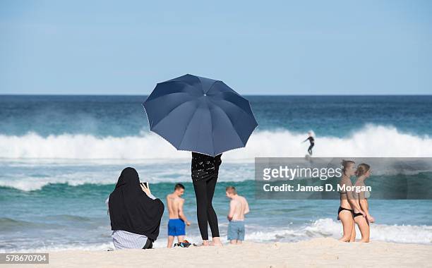Tourist holds an umbrella to shelter from the sun on Bondi Beach on July 22, 2016 in Sydney, Australia. Sydney recorded its hottest July day on...