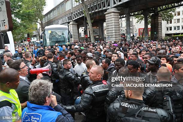 Migrants are evicted from a makeshift camp by French gendarmes, on July 22, 2016 in Paris. Between 1,200 and 1,400 people, mostly men, from Eritrea,...