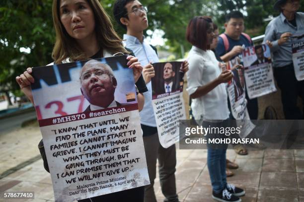 Relatives of passengers missing on Malaysia Airlines MH370 hold placards after a joint press conference of the Ministerial Tripartite Meeting on the...
