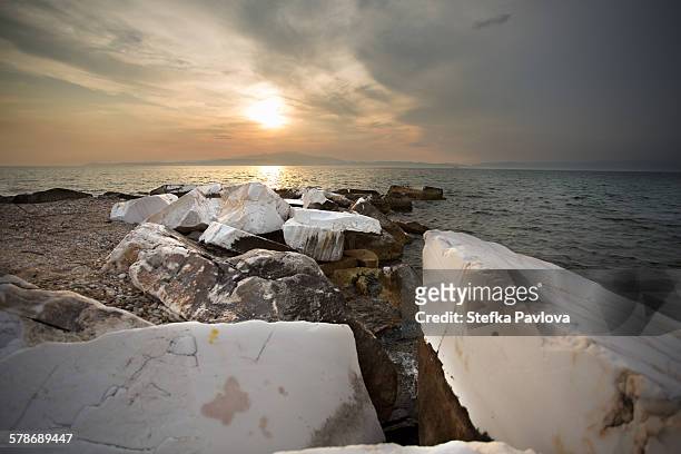 the setting sun over the aegean sea marble rocks - thasos 個照片及圖片檔