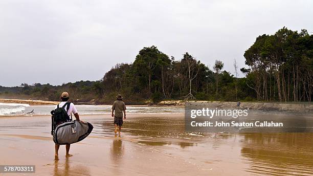 surfers walking in mayumba national park - gabão imagens e fotografias de stock