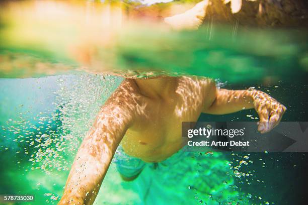 boy cooling off on a beautiful green pool in the river, swimming with underwater view on summertime in the catalan pyrenees. - hot boy body stock pictures, royalty-free photos & images