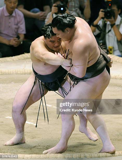 Japan - Ozeki Harumafuji sends yokozuna Hakuho out of the dohyo at Aichi Prefectural Gymnasium in central Japan on July 23 capturing his second...