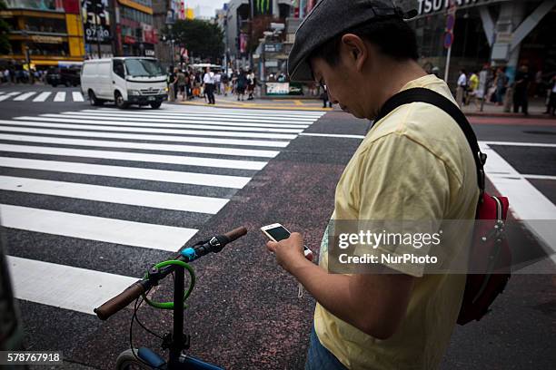 Pokemon players on bicycle stop to for a while to play &quot;Pokemon Go&quot; in the street of Shibuya district as &quot;Pokemon Go&quot; finally...