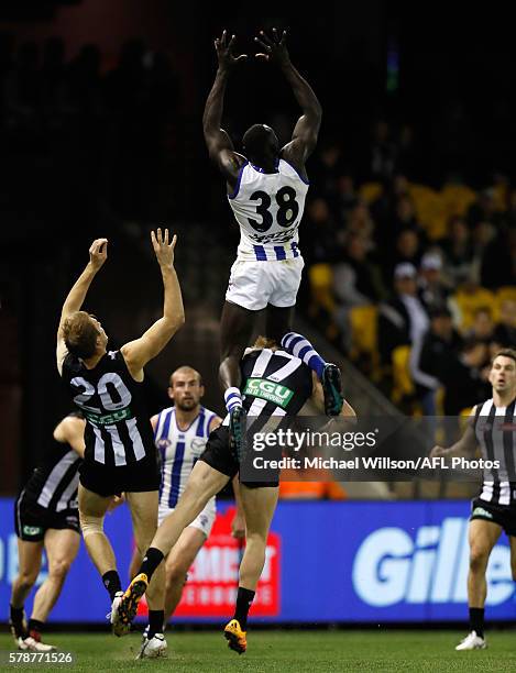 Majak Daw of the Kangaroos takes a spectacular mark over Jonathon Marsh of the Magpies during the 2016 AFL Round 18 match between the Collingwood...