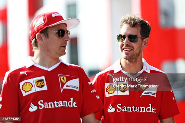 Kimi Raikkonen of Finland and Ferrari and Sebastian Vettel of Germany and Ferrari walk in the Paddock during practice for the Formula One Grand Prix...