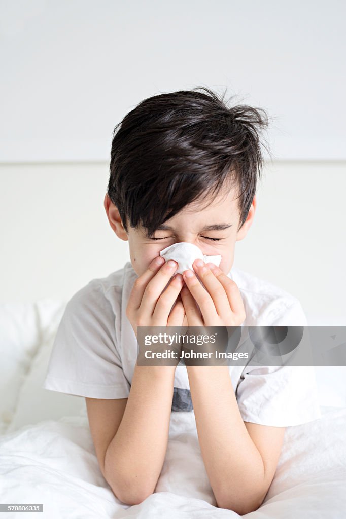 Boy blowing his nose