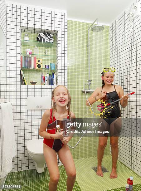 girls playing in bathroom - kids taking a shower stockfoto's en -beelden