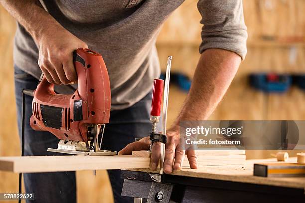 carpenter cutting a wood using jigsaw cutter - sawing stock pictures, royalty-free photos & images