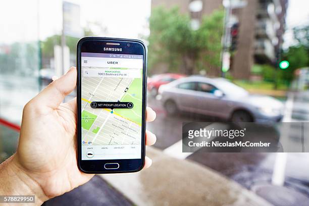 vue de perspective personnelle de la main tenant le téléphone commandant un trajet uber - uber marque déposée photos et images de collection