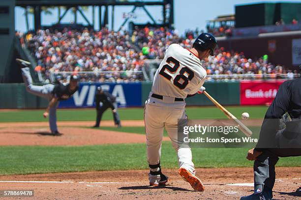 San Francisco Giants catcher Buster Posey connects with the ball at home plate, with Miami Marlins starting pitcher Jacob Turner in the distance,...