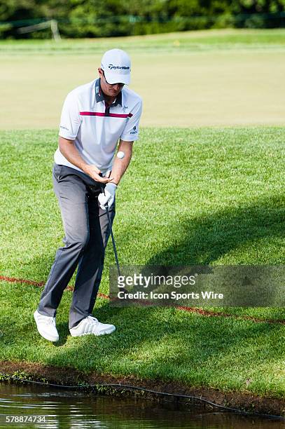Justin Rose fishes his ball out of the water on 18 and would wind up with a boogie during the final round of the Quicken Loans National at...