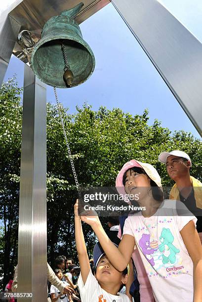 Japan - Children ring a bell to pray for the souls of the victims of the 1985 Japan Airlines jumbo jet crash before a monument, which was built for...