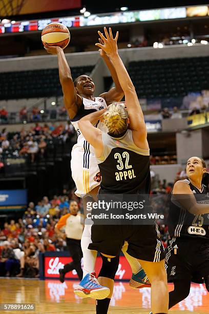 Indiana Fever forward Tamika Catchings drives the lane and puts up her shot over San Antonio Stars center Jayne Appel during the game between the San...