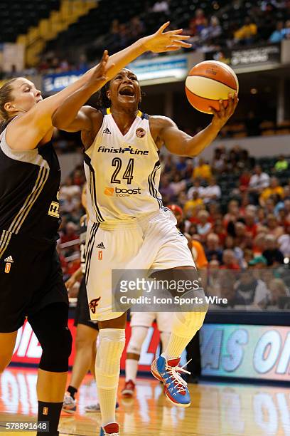 Indiana Fever forward Tamika Catchings drives past San Antonio Stars center Jayne Appel on her way to the basket during the game between the San...