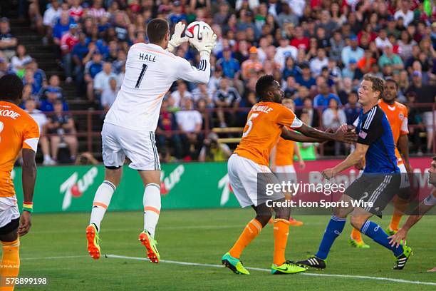 Houston Dynamo goalkeeper Tally Hall jumps for the save as San Jose Earthquakes defender Ty Harden watches and Houston Dynamo defender Warren...