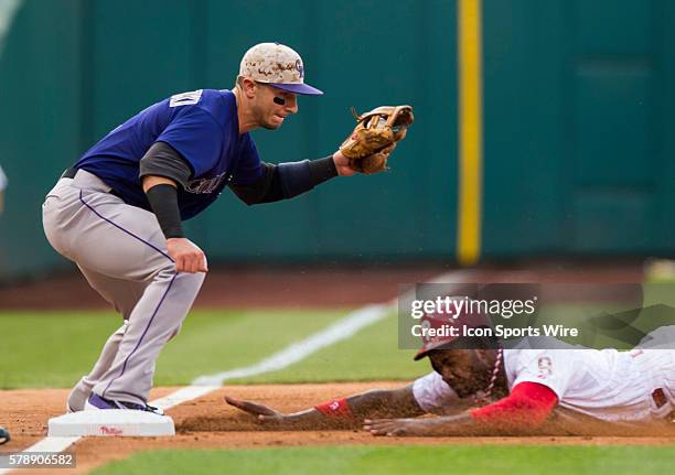 Philadelphia Phillies left fielder Domonic Brown slides into third base safely avoiding Colorado Rockies shortstop Charlie Culberson during a Major...