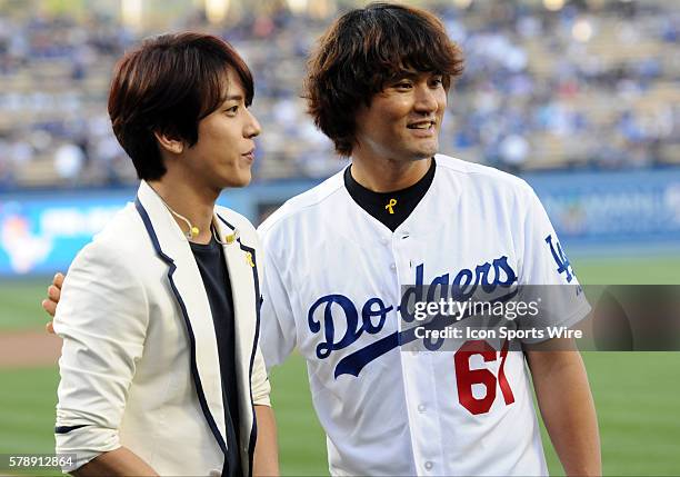 Korean singer Yong-Wa Jung poses with former Dodger pitcher Chan Ho Park during a Major League Baseball game between the Cincinnati Reds and the Los...