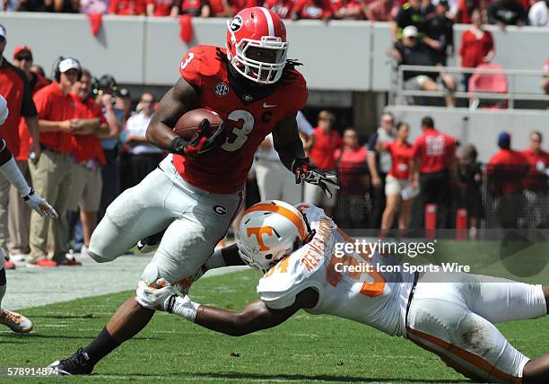 Todd Gurley Georgia Bulldogs running back rushes for yardage as Jalen Reeves-Maybin Tennessee Volunteers linebacker attempts to make the tackle...