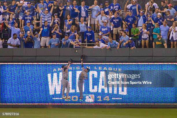 Oakland Athletics outfielders miss a near home run by Kansas City Royals first baseman Eric Hosmer as fans cheer during the American League Wild Card...