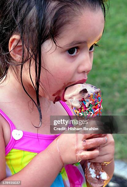 young girl eating and licking ice cream cone - girl eating messy ice cream cone stock-fotos und bilder