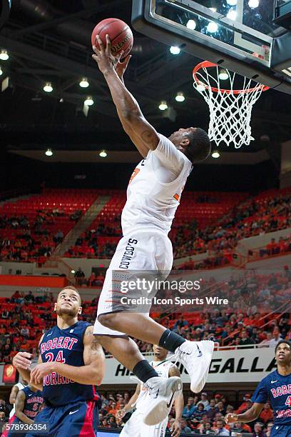 Oklahoma State Cowboys guard Marcus Smart goes up for a backwards dunk during the NCAA basketball game between the Robert Morris University Colonials...