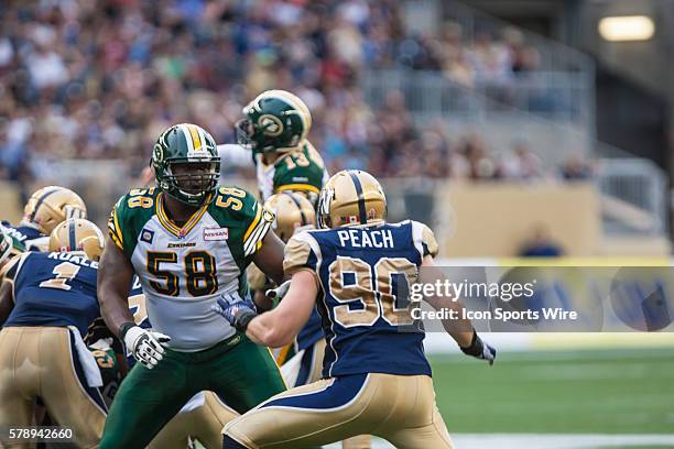 July 2014 Eskimos Tony Washington blocks Blue Bombers Greg Peach during the Eskimos vs Bombers game at the Investors Group Field in Winnipeg MB.