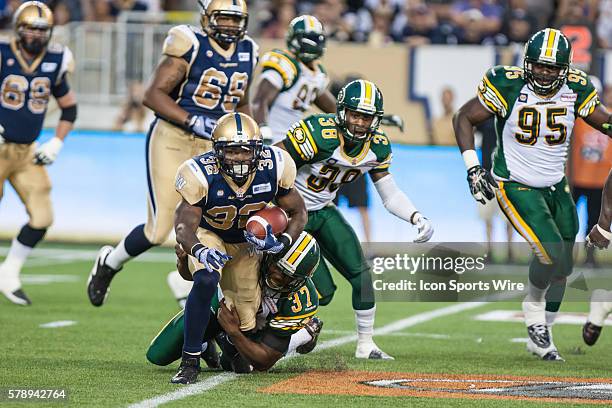 July 2014 Blue Bombers Nic Grisby i tackled by Eskimos Otha Foster during the Eskimos vs Bombers game at the Investors Group Field in Winnipeg MB.