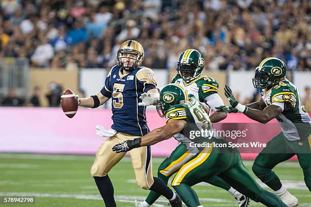 July 2014 Blue Bombers Drew Willy is hurried by Eskimos Eddie Steele during the Eskimos vs Bombers game at the Investors Group Field in Winnipeg MB.