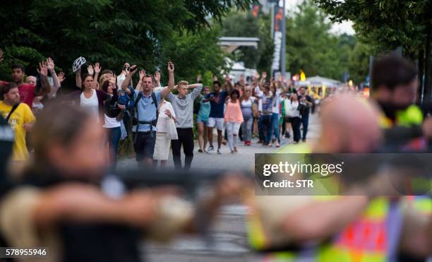 Police escorts evacuated people from the shopping mall (the Olympia Einkaufzentrum in Munich on July 22, 2016 following a shootings earlier. At least...