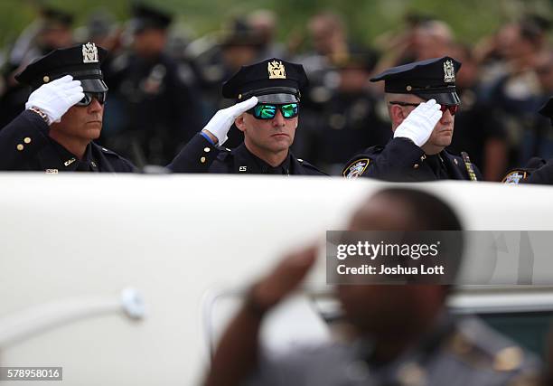 Police officers salute during the funeral procession for Baton Rouge Police Officer Matthew Gerald at Healing Place Church Arena on July 22, 2016 in...
