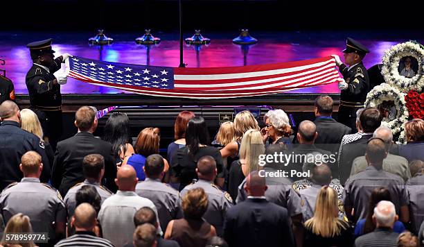 Police honor guard drape an American flag over the casket of Baton Rouge police officer Matthew Gerald during his funeral at the Healing Place Church...