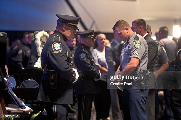 Police officers pay their respects in front of the casket, left, of Baton Rouge police officer Matthew Gerald at the Healing Place Church July 22,...