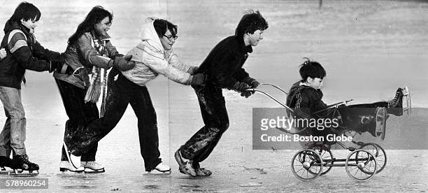From left, Mike Morley Shannon Murray Diane Wilcox and Larry Fowler push Brian Havlin, 8 through Columbus Park in South Boston on Jan. 10, 1980.