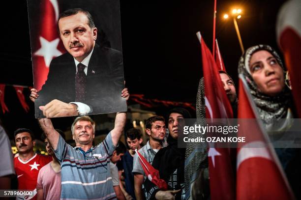 Man holds up a photo of Turkey's President Recep Tayyip Erdogan during a Pro-Erdogan rally in Taksim square in Istanbul on July 22 following the...