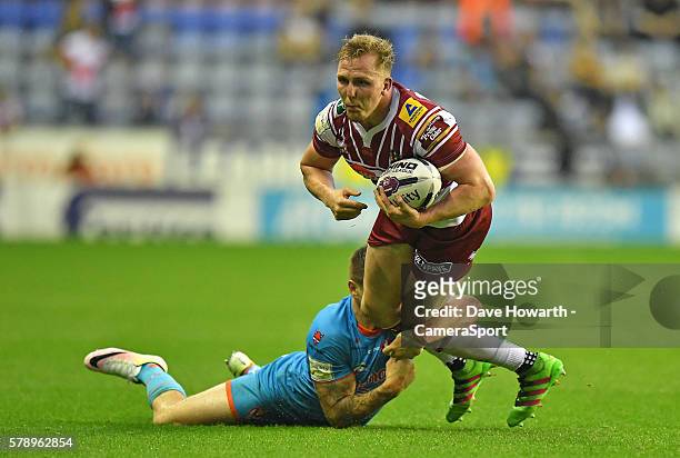 Dan Sarginson of Wigan Warriors is tackled by St Helens' Mark Percival during the First Utility Super League Round 23 match between Wigan v St Helens...