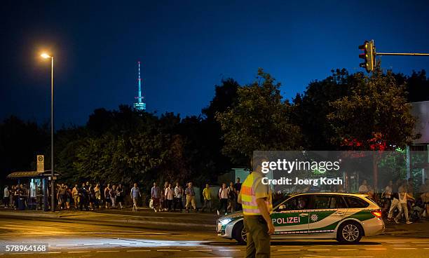 Police officers escort people from inside the shopping center as they respond to a shooting at the Olympia Einkaufzentrum at July 22, 2016 in Munich,...