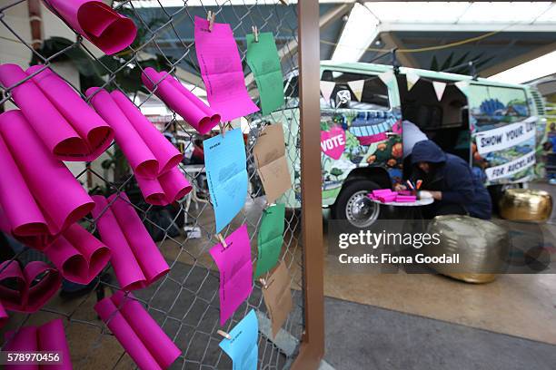 People write love notes to Auckland outside the Love Bus parked in Mangere Town Centre on July 23, 2016 in Auckland, New Zealand. The van is part of...