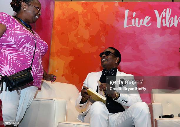 Singer Charlie Wilson signs an autograph for a fan at the State Farm Color Full Lives Art Gallery during the 2016 State Farm Neighborhood Awards at...