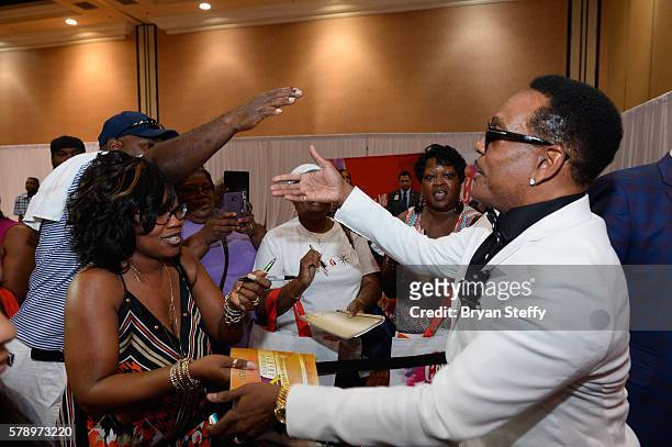 Singer Charlie Wilson signs an autograph for fans at the State Farm Color Full Lives Art Gallery during the 2016 State Farm Neighborhood Awards at...
